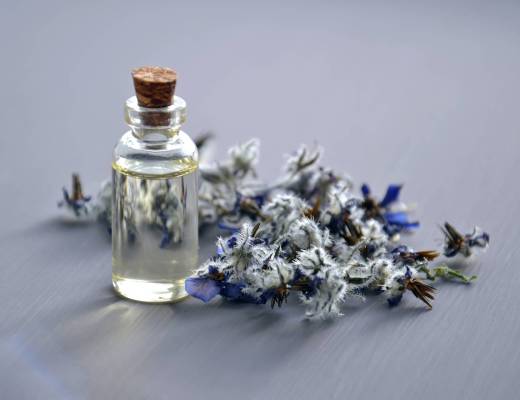 perfume bottles with small flowers next to it