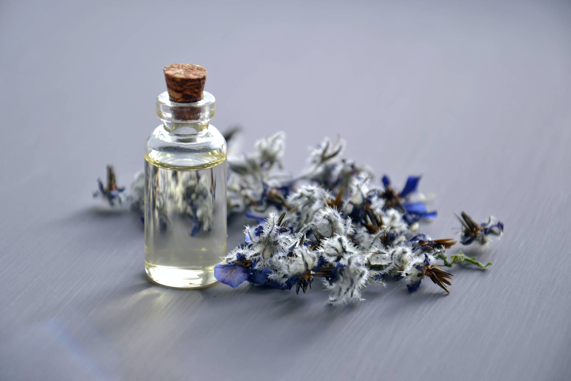 perfume bottles with small flowers next to it