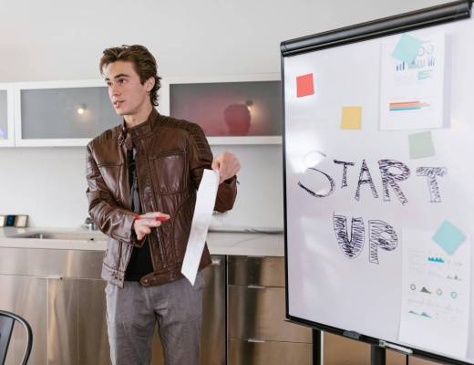 male entrepreneur presenting in front of a whiteboard