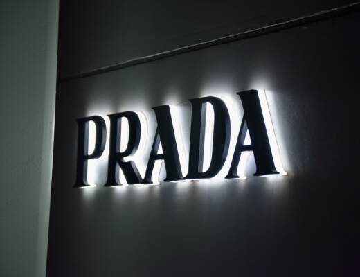 Illuminated prada logo on a dark wall shows brand recognition