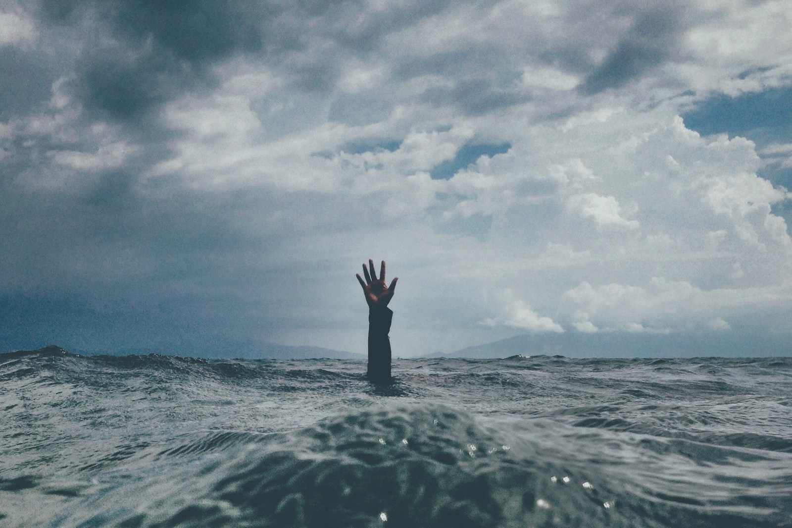 photo of person reach out above the water; burnout