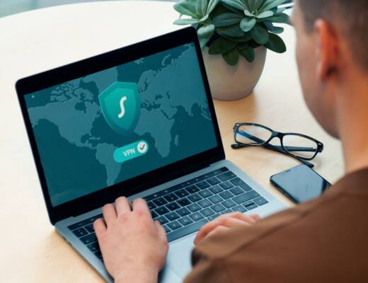 person using macbook pro on white table: cybersecurity