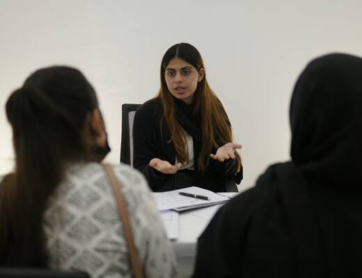 Woman gesturing while talking to two people; communication