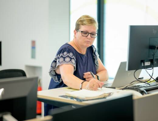 a person sitting at a desk; bookkeeper