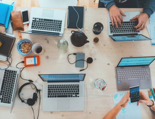 people sitting down near table with assorted laptop computers; break-even point