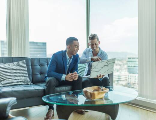 two men in suit sitting on sofa; Customer Churn