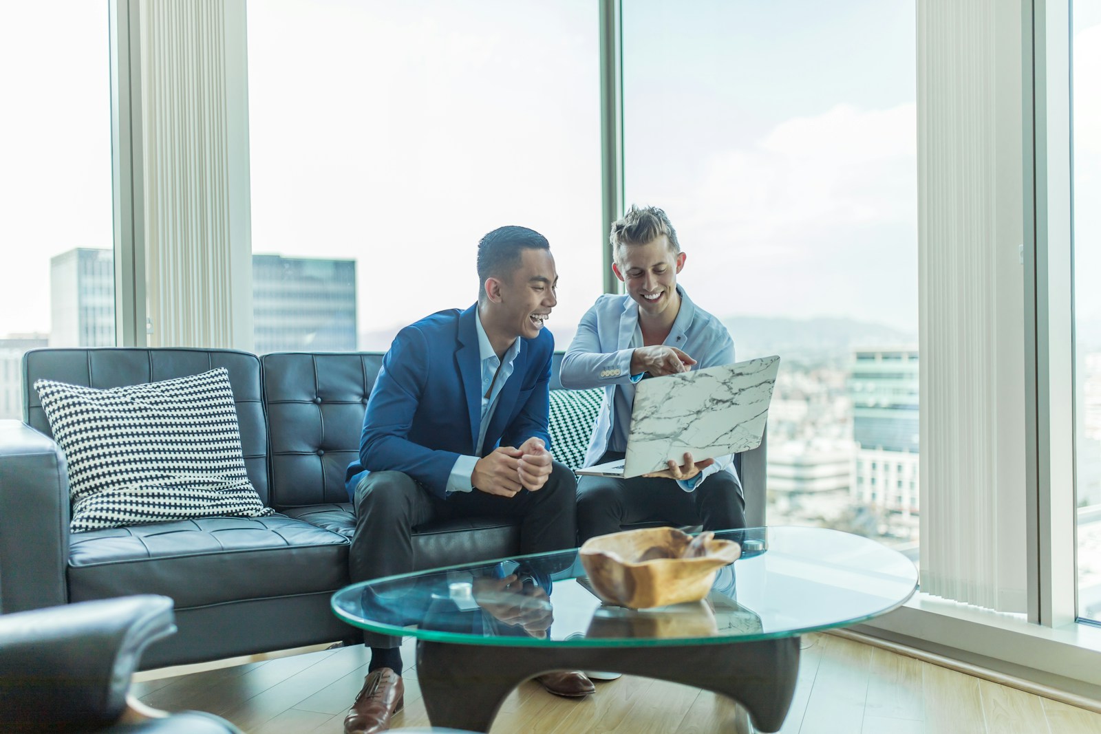two men in suit sitting on sofa; Customer Churn