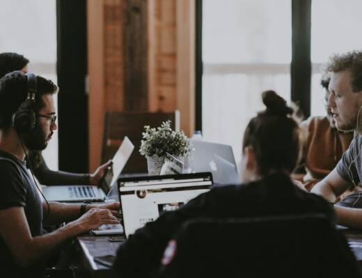 selective focus photography of people sits in front of table inside room; delegate