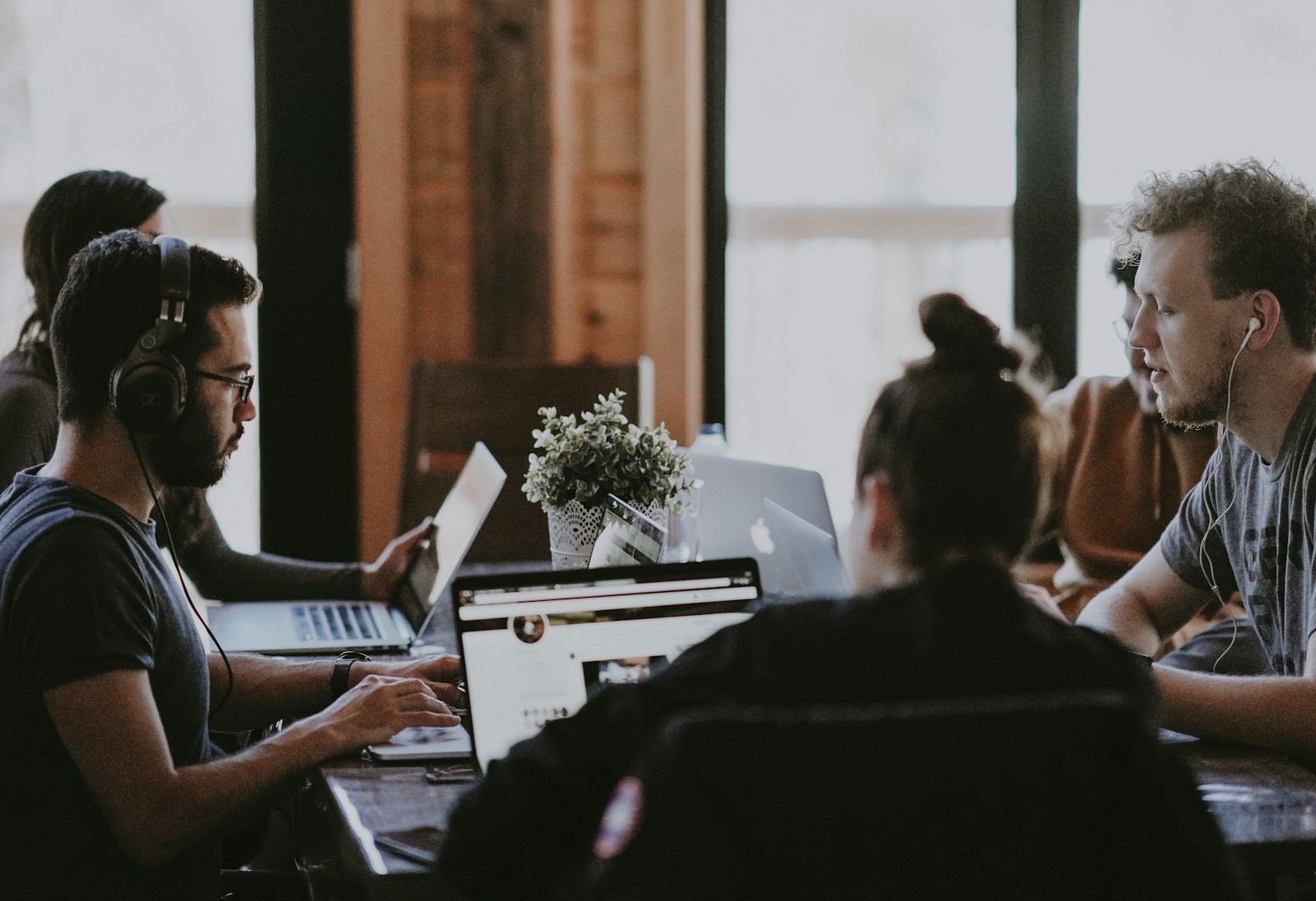 selective focus photography of people sits in front of table inside room; delegate