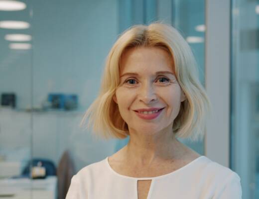 A smiling blonde woman in a white shirt indoors.;Emotionally Mature