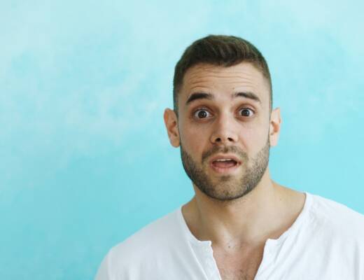 Man with surprised expression against blue background; Founder Behaviors