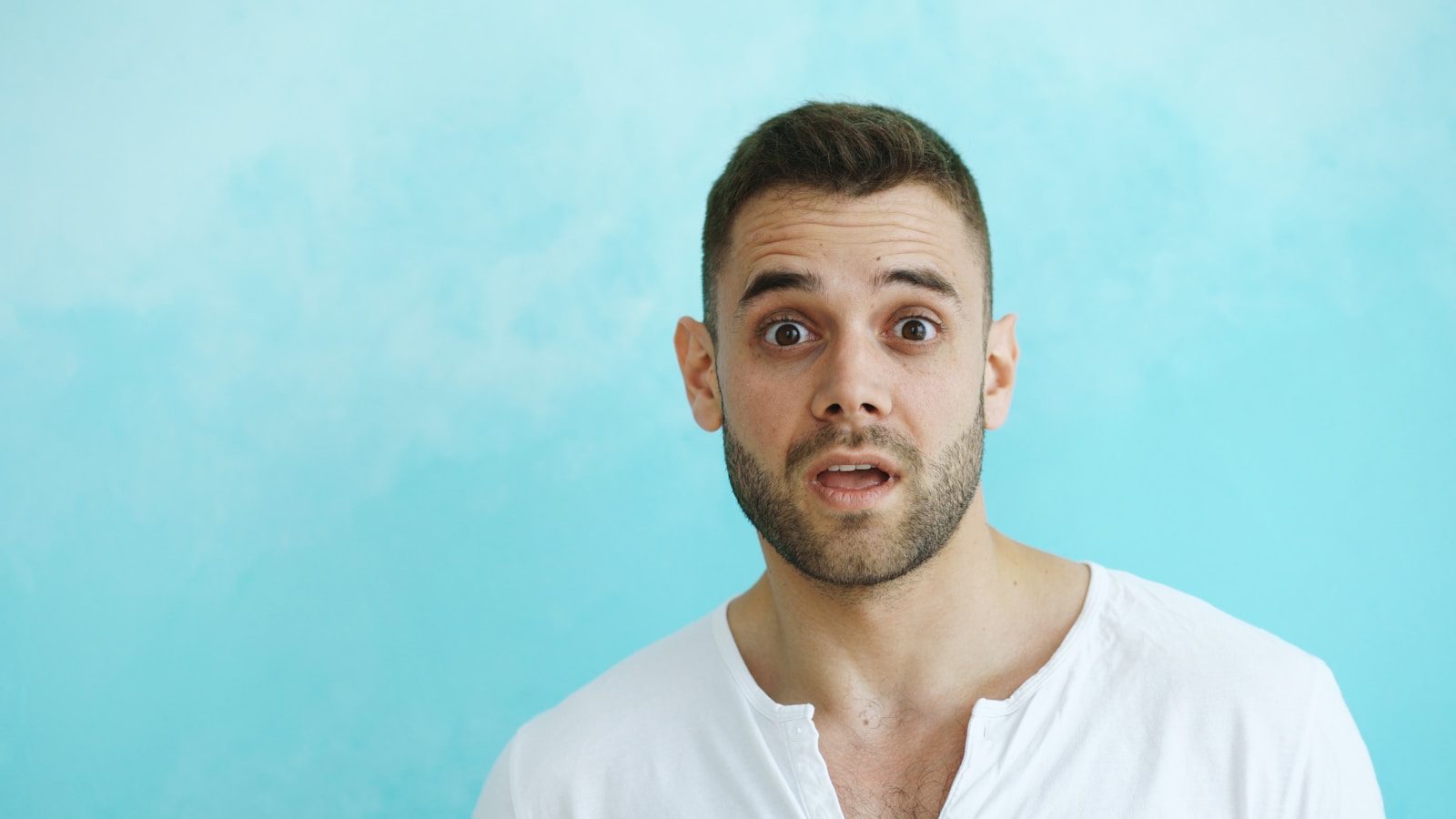 Man with surprised expression against blue background; Founder Behaviors