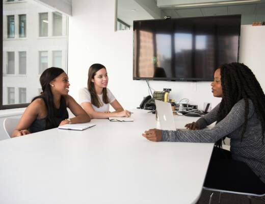 three women sitting at the table; Hire Your First Employee