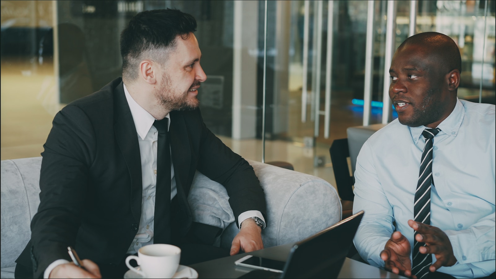 Two businessmen in suits talking at a table; co founder breakup