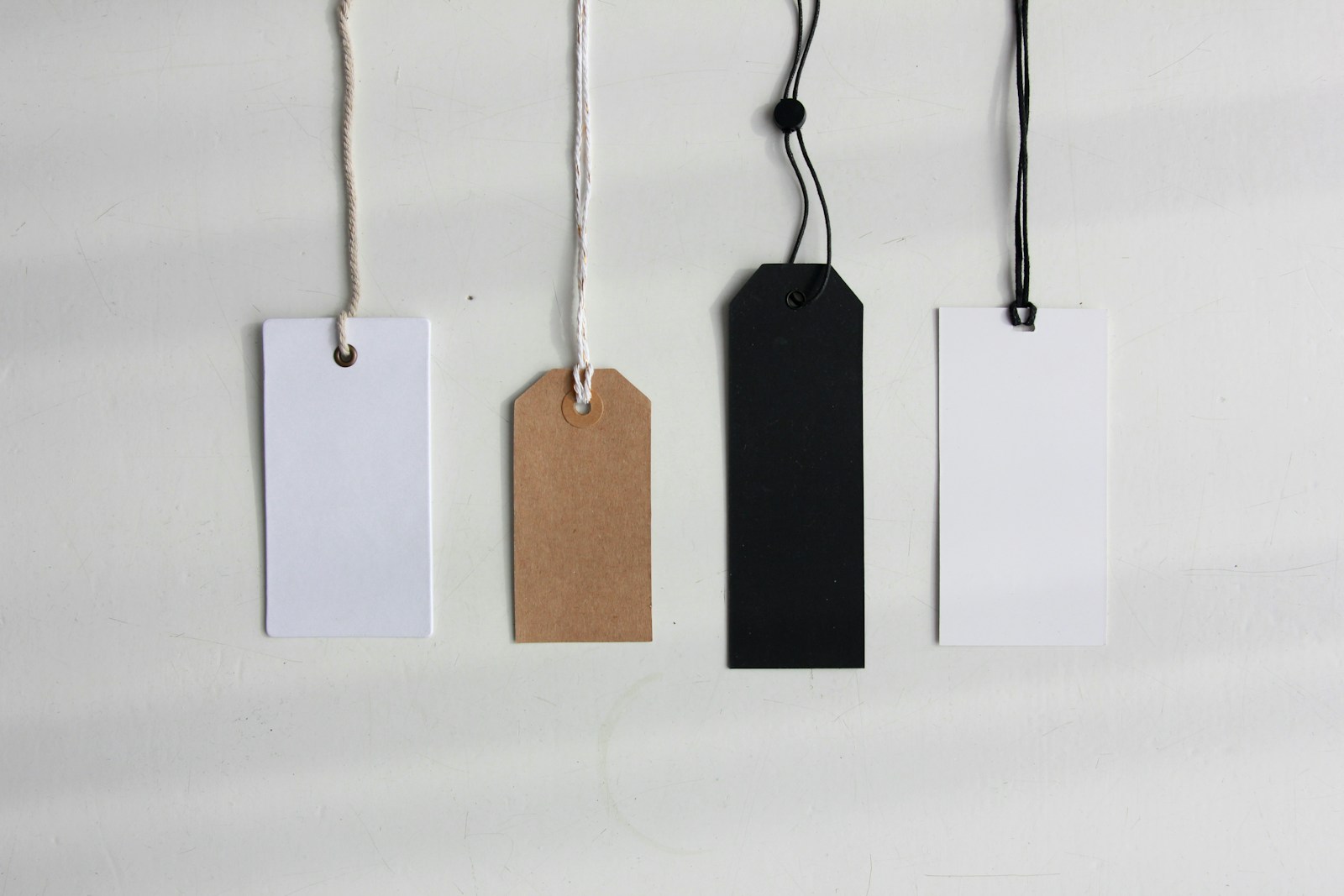 four paper card tags; pricing