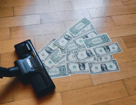 a pile of money sitting on top of a wooden floor; Money Conversation