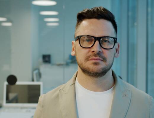Man with glasses in a modern office setting; Product-Market Fit