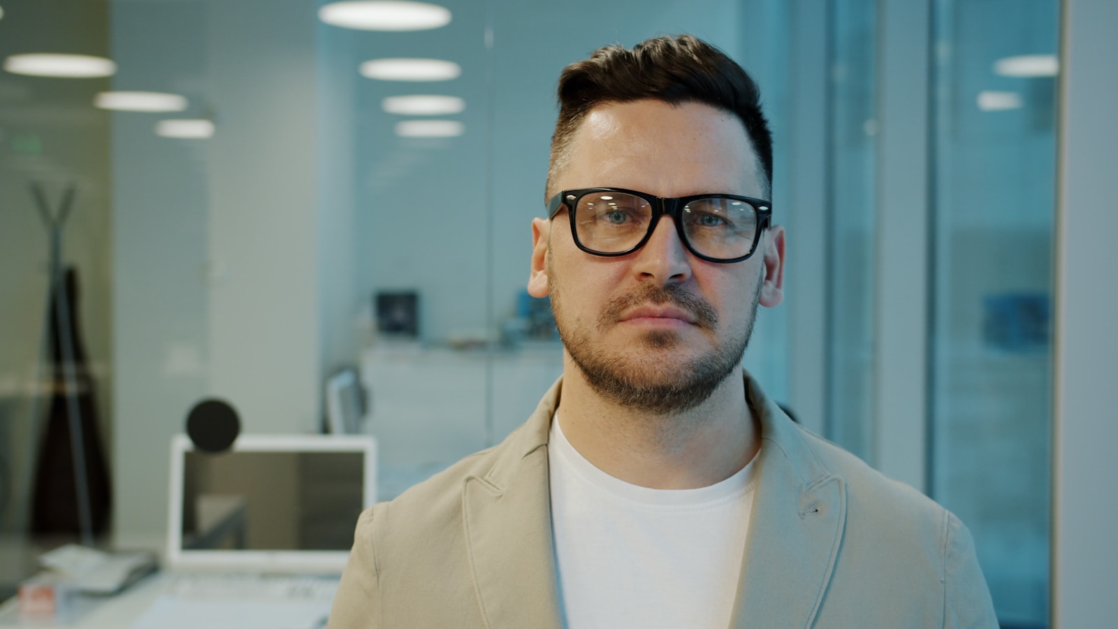 Man with glasses in a modern office setting; Product-Market Fit