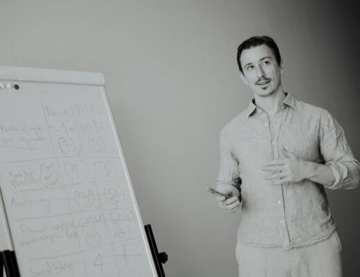 Man presenting at a whiteboard in a meeting working on growth.