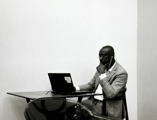 a man sitting at a desk with a laptop and doubt.