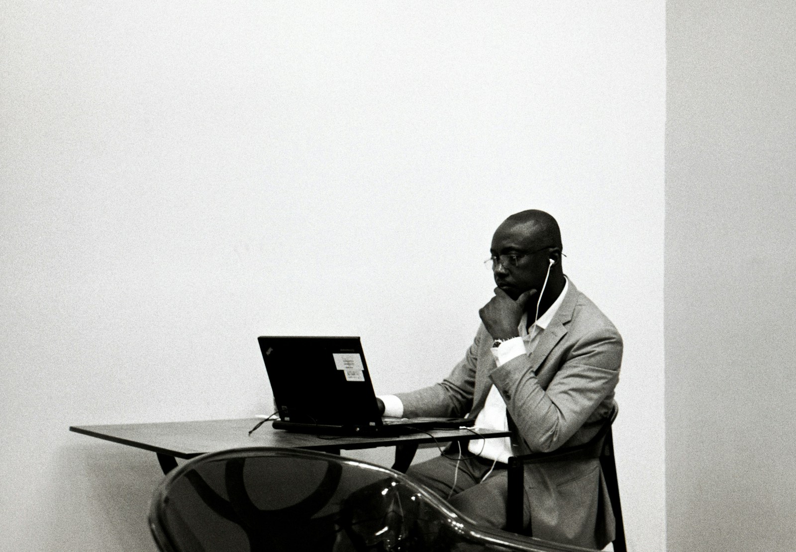 a man sitting at a desk with a laptop and doubt.