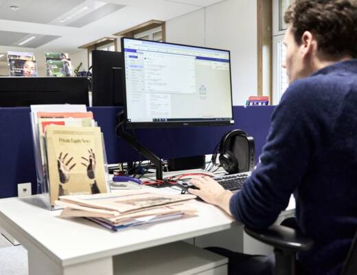 Man working at a computer in an office; service business minimal investment