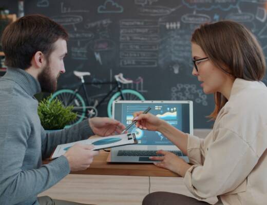 Two colleagues reviewing data on a laptop; slow startup growth