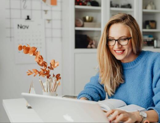 Entrepreneur wearing light blue sweater working from home and remotely managing shipping operations for her business; Free Shipping Platforms
