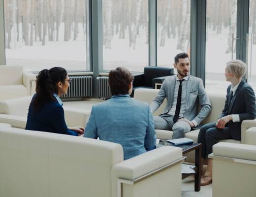 Four professionals in a modern office meeting space; founders feeling like frauds