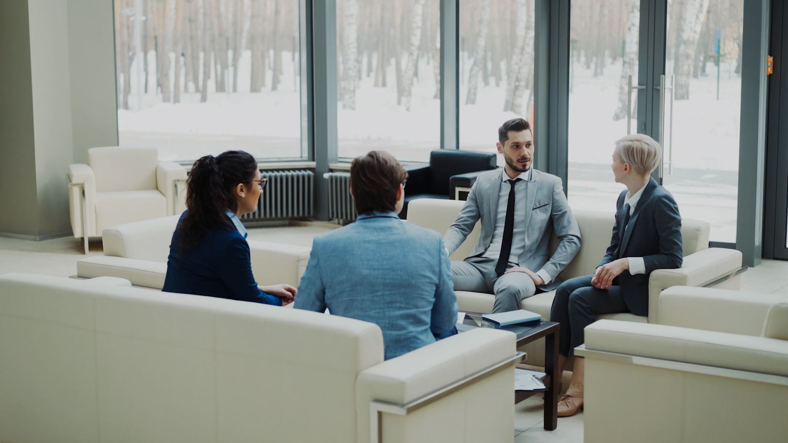 Four professionals in a modern office meeting space; founders feeling like frauds