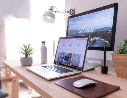MacBook Pro on table beside white iMac and Magic Mouse; successful remote business fundamentals