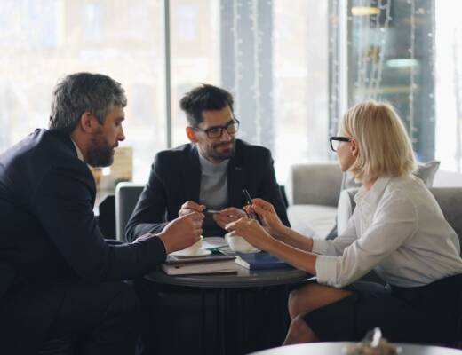 a group of people sitting around a table; business leadership