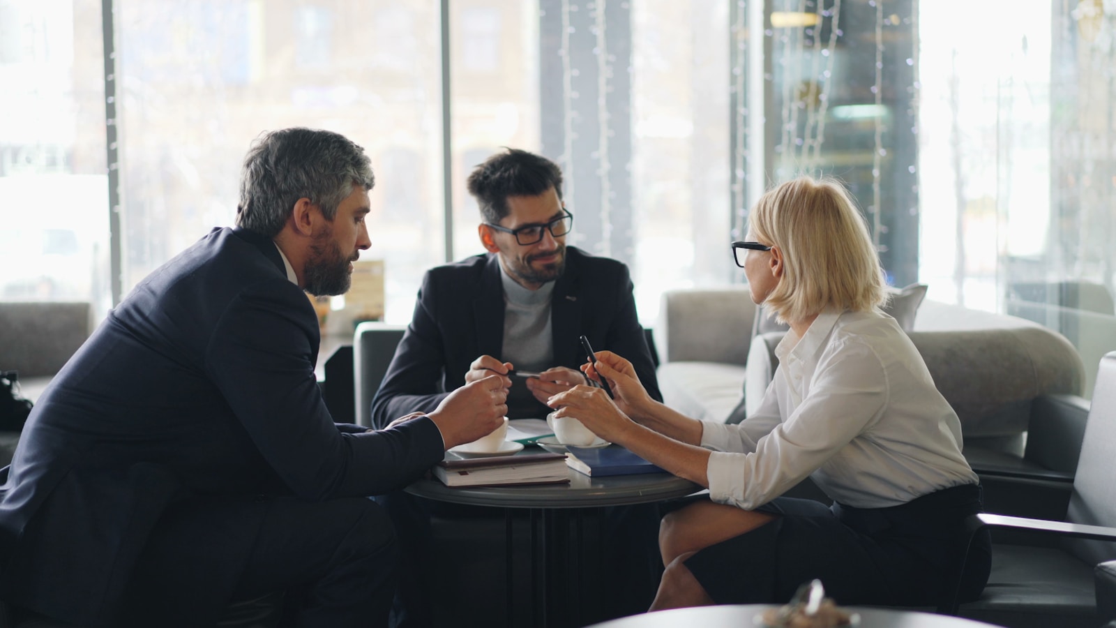 a group of people sitting around a table; business leadership