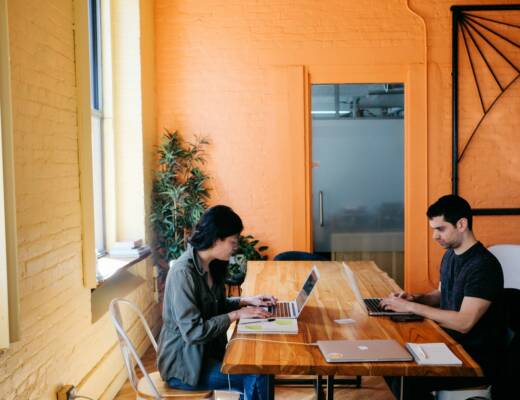 man and woman on software teams using laptop on table