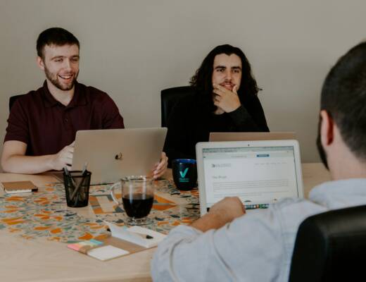 three people sitting at conference table with laptop computers discussing startup funding; founders lose investor trust
