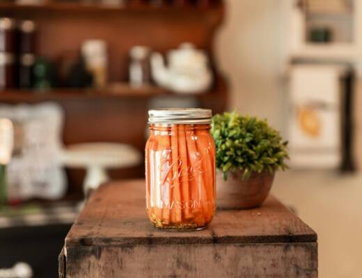 a jar of pickled carrots sitting on a table; enhancing product shelf life