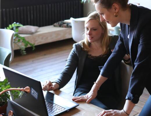 two women looking at a laptop on a table; questions smart founders ask
