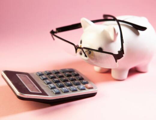 A piggy bank wearing glasses next to a calculator; financial systems save founders