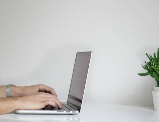 person using laptop; leverage job build wealth