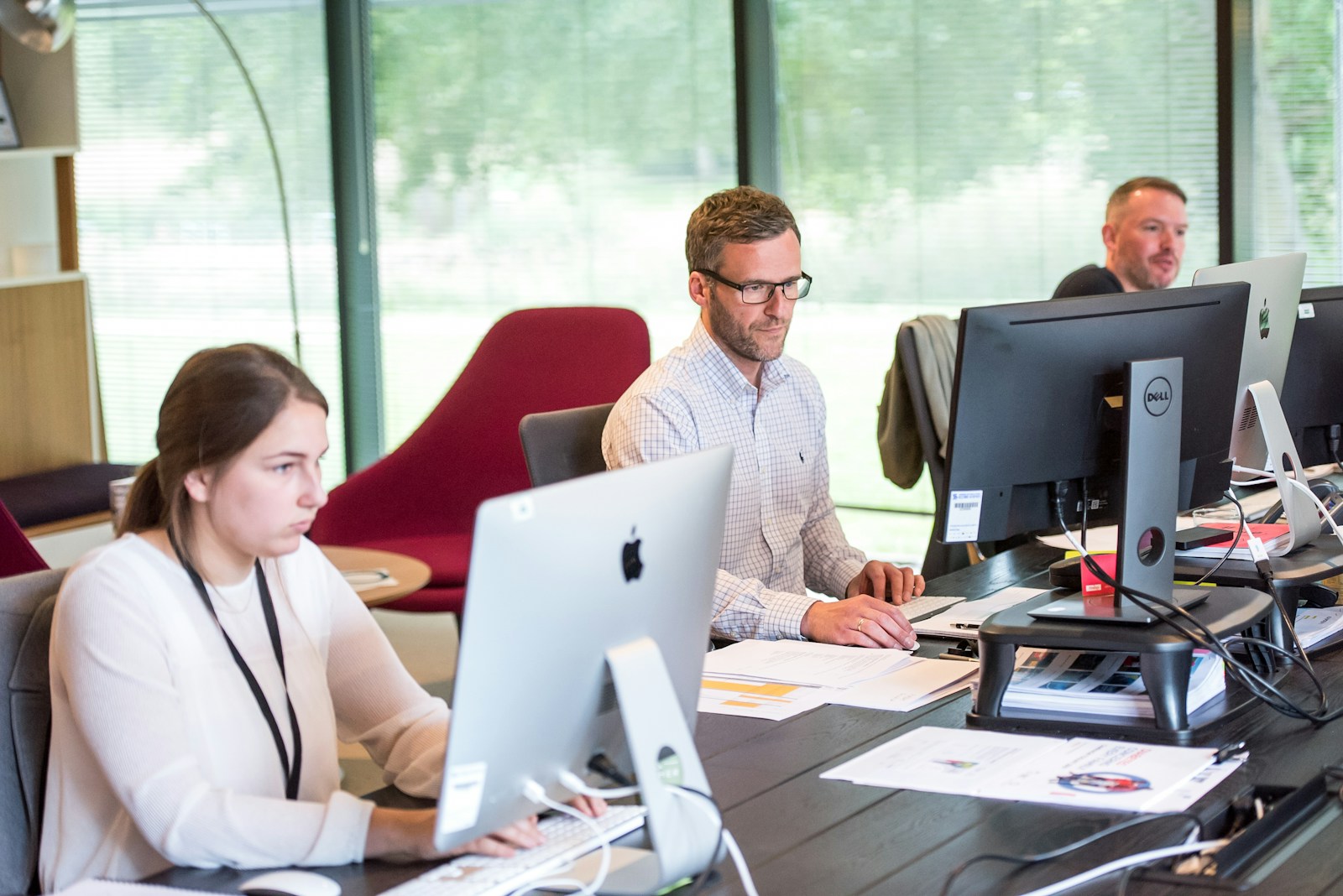 employees working on their computers at large shared desk; cache management internet performance