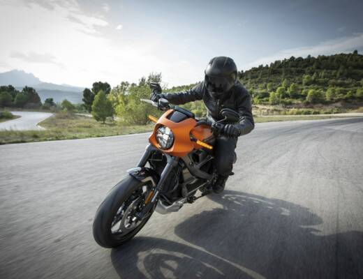 person driving orange motorcycle; young entrepreneurs rethinking commute