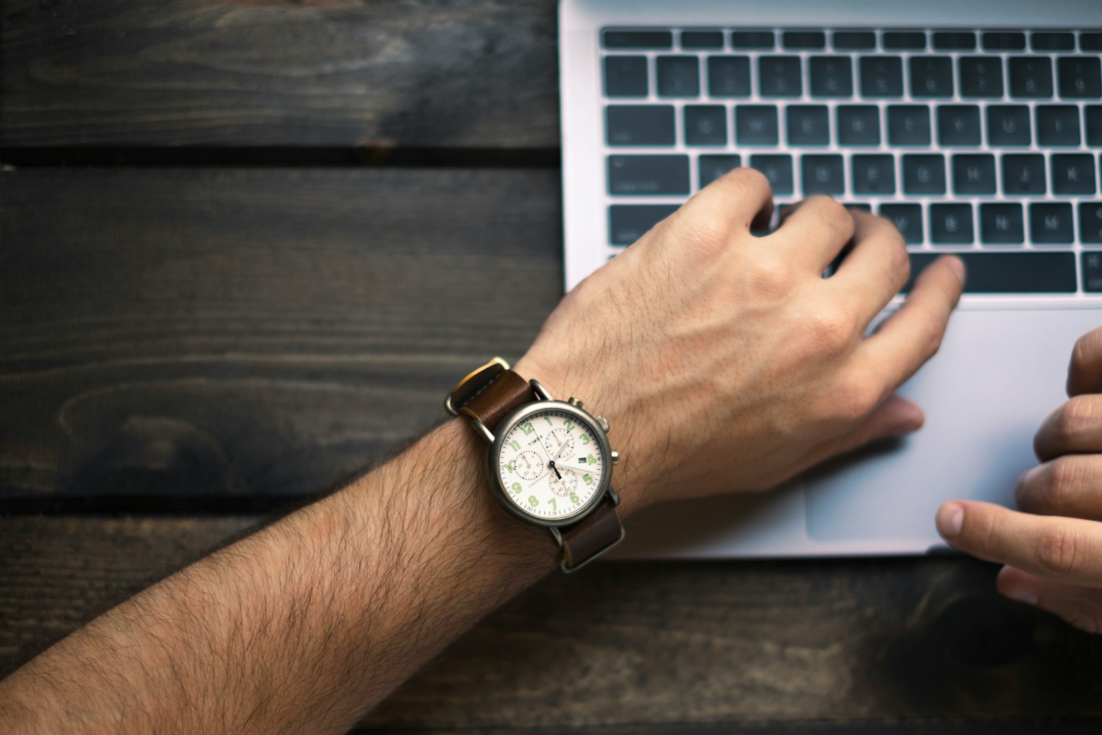 person wearing brown and white watch checking the time while working on laptop; founders schedule think time