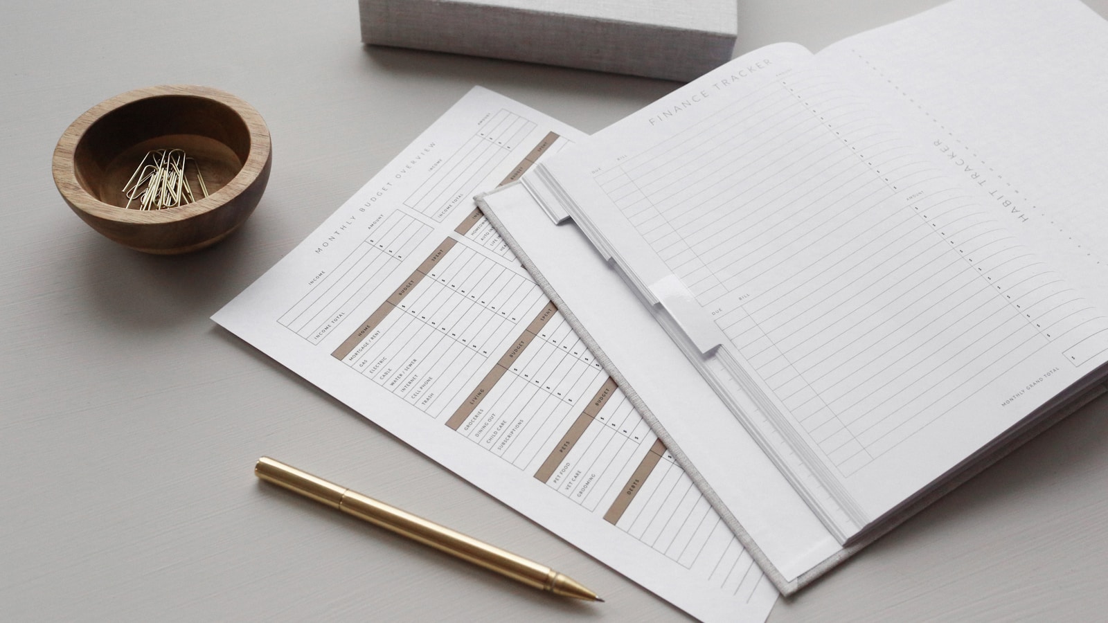 Image of financial documents and gold pen on desk; cosigning financial self-sabotage
