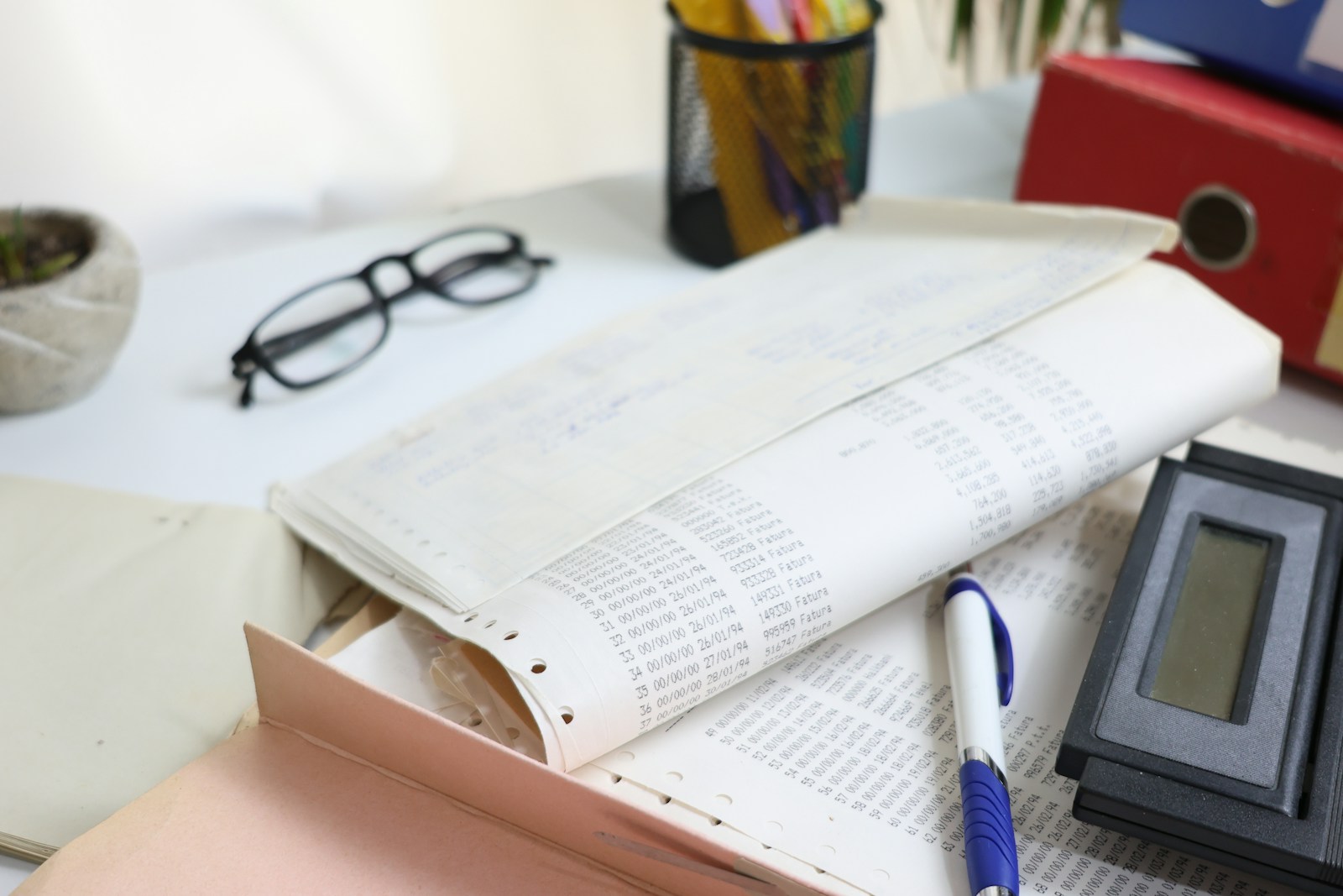 Desk with papers, glasses, calculator, and office supplies; underpaying yourself killing business