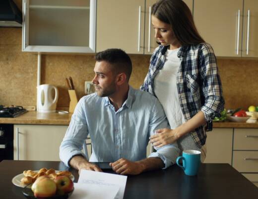 Couple sitting at kitchen table with pastries brainstorming personal finance strategy; stop hoping start working