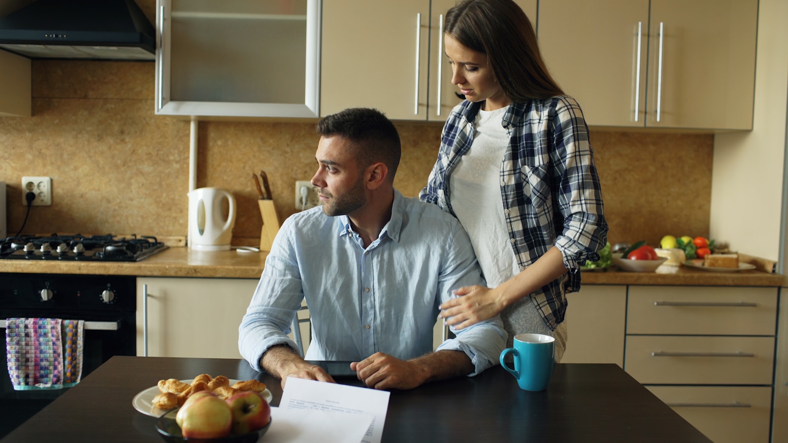 Couple sitting at kitchen table with pastries brainstorming personal finance strategy; stop hoping start working