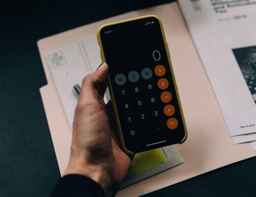 Person calculating finances with phone calculator; money control isolation
