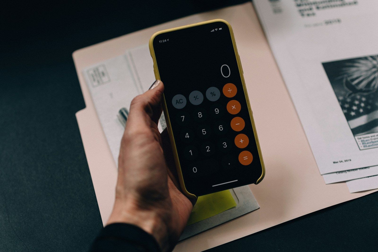 Person calculating finances with phone calculator; money control isolation