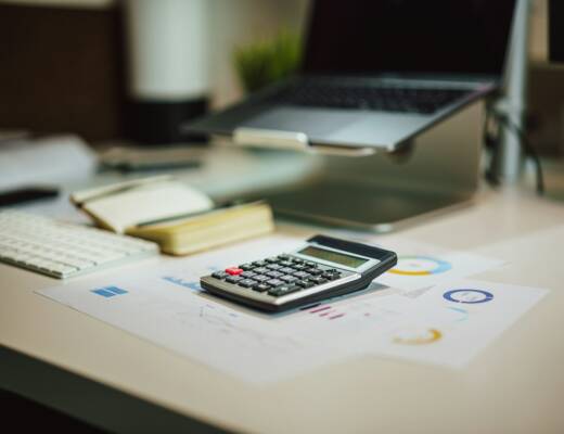 a calculator sitting on desk next to a laptop; living like broke lawyers