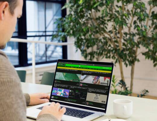 A man sitting at a desk using a laptop computer; become successful
